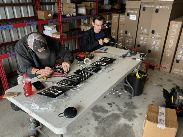 Technicians programming Lutron keypads at workbench before installation